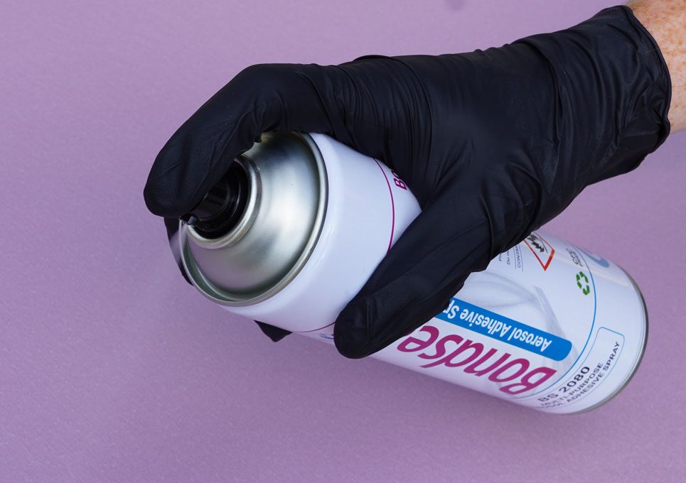 gloved hand spraying aerosol